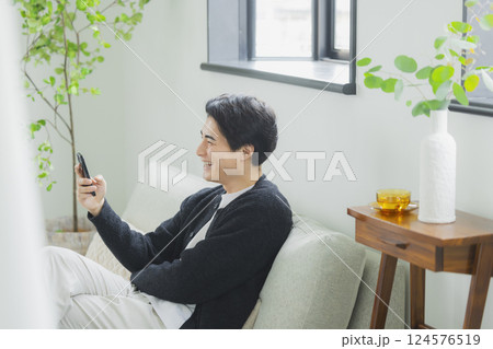 リビングでスマホを使う男性 リビングでスマホを使う男性 124576519