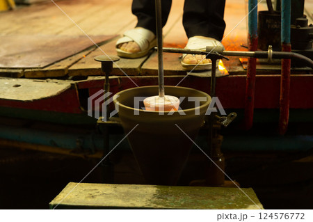 A mesmerizing close-up of a skilled artisan blowing molten glass into shape A mesmerizing close-up of a skilled artisan blowing molten glass into shape 124576772