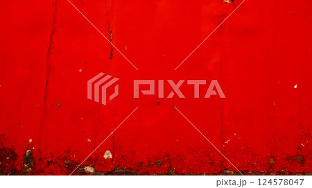 Red grunge background with cracked texture and peeling paint, suitable for urban style designs and vintage artistic projects, bold and rough pattern 124578047