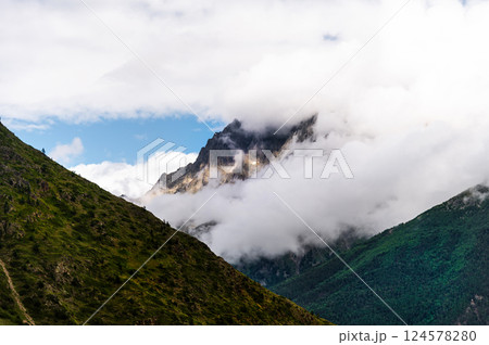 Picturesque mountain landscape. View of the mountain in the snow, covered with fog. Colorful travel background 124578280