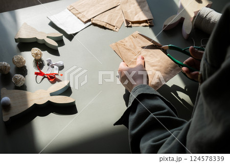 DIY process of woman making candid Easter present paper bag bunny arrangement decor. Series of handmade craft paper gift idea instruction manual activity for children. Zero waste eco-friendly 124578339