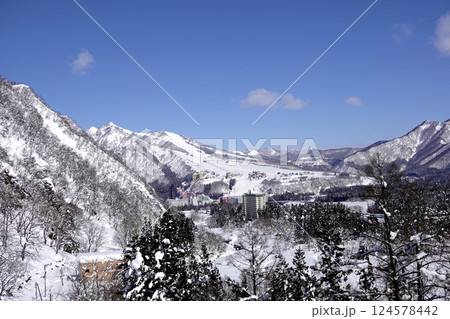 冬のリゾート山間部 マンション群の先にスキー場を遠望する 124578442