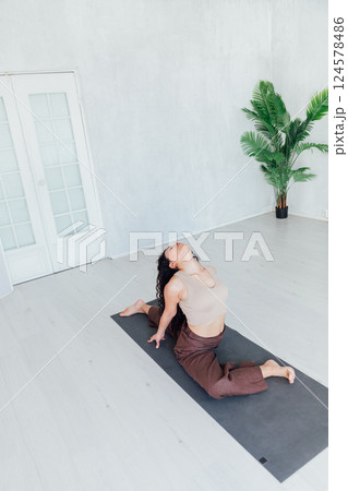 Brunette Yoga Woman Doing Asana Gymnastics On Floor Brunette Yoga Woman Doing Asana Gymnastics On Floor 124578486