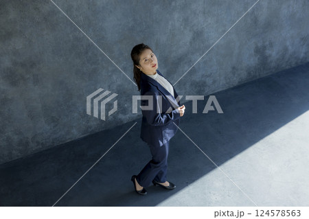 歩くスーツ姿の女性　 124578563