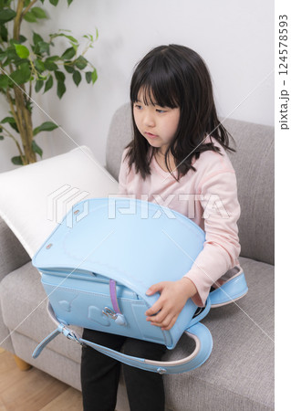 ランドセルを抱えて座る小学一年生の女の子 124578593