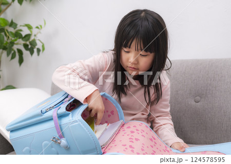 ランドセルを抱えて座る小学一年生の女の子 ランドセルを抱えて座る小学一年生の女の子 124578595