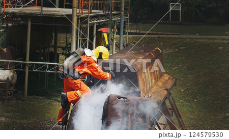 Firefighter fighting smoke flame use fire hose chemical water foam spray engine. Firefighter Rescue training in fire fighting extinguisher. Fireman wear hard hat safety suit uniform for protection Firefighter fighting smoke flame use fire hose chemical water foam spray engine. Firefighter Rescue training in fire fighting extinguisher. Fireman wear hard hat safety suit uniform for protection 124579530