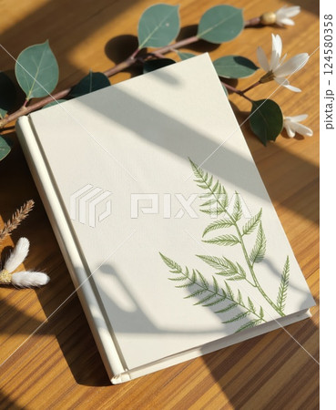 Nature-inspired journal design with fern motif on wooden surface for creative writing 124580358