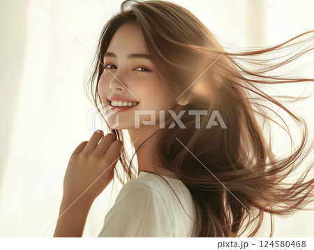 逆光で振り向く柔らかい髪の毛の女性 124580468