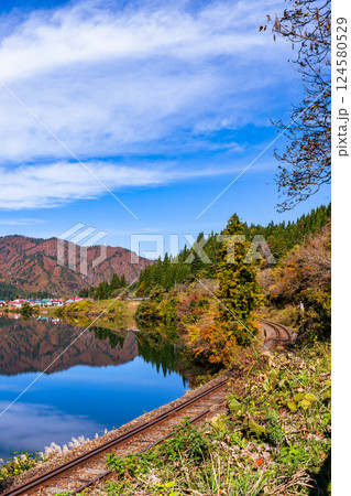Fukushima, JAPAN - Nov 10, 2024: Tadami Line train tracts run along Tadami Riverside in autumn at Aizu-Kawaguchi, Mishima, Fukushima 124580529