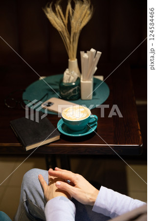Woman reading a book and drinking coffee at restaurant 124584466