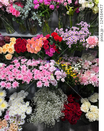 Many different flowers on the shelves of the florist's store 124584477