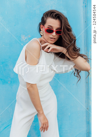 Beautiful Slim Fashion Woman in White Suit on Blue Background Beautiful Slim Fashion Woman in White Suit on Blue Background 124584544