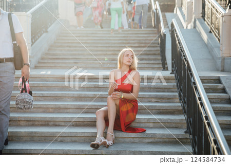 Lonely woman in a red dress among people 124584734