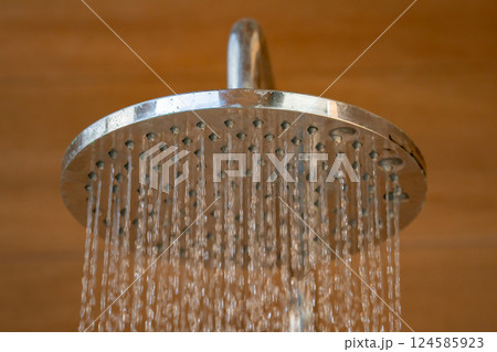 Close up to Outdoor shower head for the bath and showering cold water to body before jumping in the resort pool. Close up to Outdoor shower head for the bath and showering cold water to body before jumping in the resort pool. 124585923