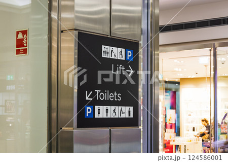 Modern shopping center sign showing directions for lift, restrooms, and parking 124586001