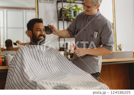 A Skilled Barber is Providing a Fresh and Stylish Haircut to a Client in a Trendy Salon Setting 124586205