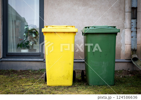 Yellow and Green Trash Bins Next to Building 124586636