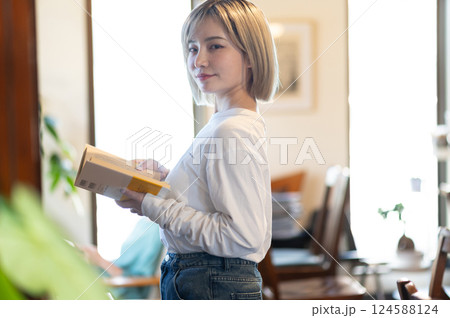 本棚の前で本を読む女性 本棚の前で本を読む女性 124588124