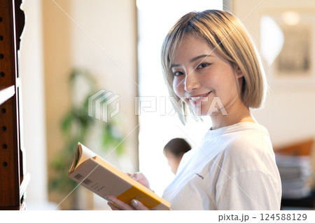 本棚の前で本を読む女性 本棚の前で本を読む女性 124588129