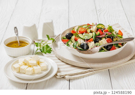 greek salad of veggies, olives, cheese in bowl 124588190