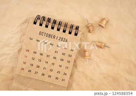 October 2026 desk calendar with wooden thumbtack on brown crumpled paper. October 2026 desk calendar with wooden thumbtack on brown crumpled paper. 124588354
