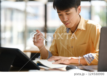 University student reading a textbook and studying for exams University student reading a textbook and studying for exams 124588990