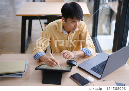 Student studying online and preparing for exams with digital devices and books 124588998
