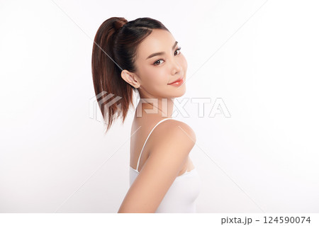 A beautiful young Asian woman with clean, fresh skin against a white background. Skincare, facial treatment, cosmetology, beauty, and spa. An elegant portrait of an Asian woman. 124590074