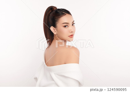 A beautiful young Asian woman with clean, fresh skin against a white background. Skincare, facial treatment, cosmetology, beauty, and spa. An elegant portrait of an Asian woman. 124590095