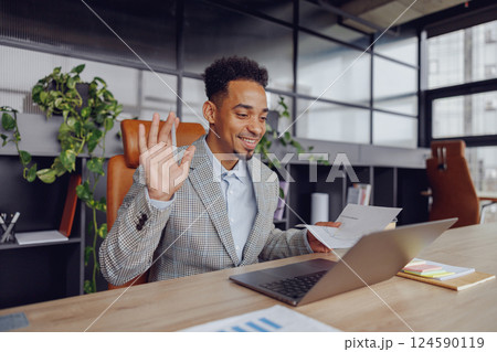A Professional Man Actively Engaging in a Virtual Meeting Set in a Modern Office Space A Professional Man Actively Engaging in a Virtual Meeting Set in a Modern Office Space 124590119