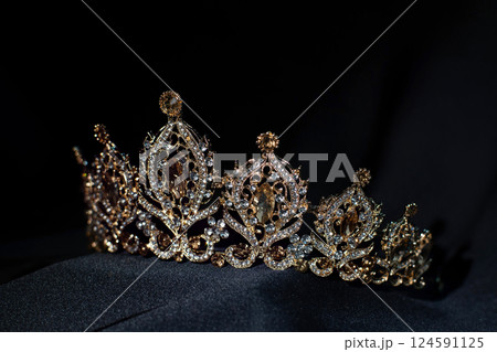 Royal golden crown with citrine gemstones and diamonds on dark background Royal golden crown with citrine gemstones and diamonds on dark background 124591125