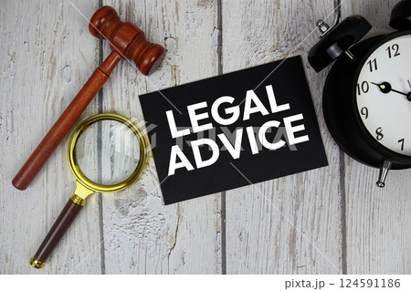 Legal Advice text on paper card with alarm clock and wooden judge gavel top view on wooden background Legal Advice text on paper card with alarm clock and wooden judge gavel top view on wooden background 124591186