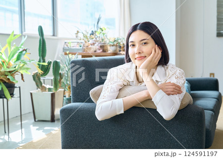 リビングのソファに寝転がって微笑む女性 124591197