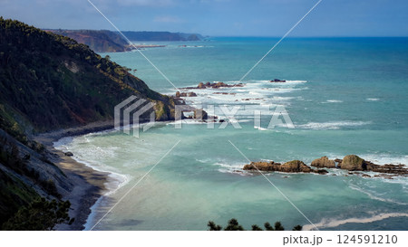 Panoramic view of a rugged coastline with turquoise sea, dramatic cliffs, and rock formations 124591210