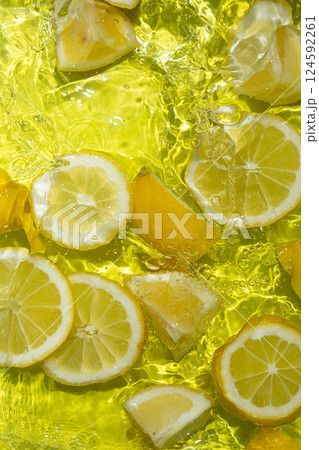 Vibrant yellow lemon pieces floating in motion water Vibrant yellow lemon pieces floating in motion water 124592261