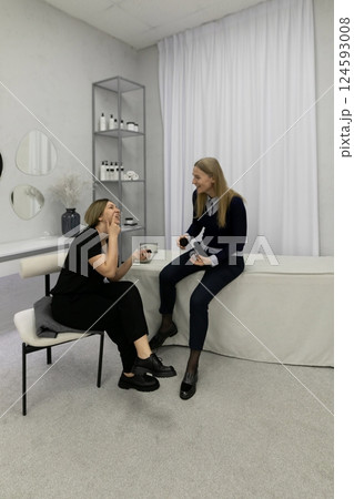 Women enjoying a casual conversation while seated in a stylish modern spa setting during the 124593008