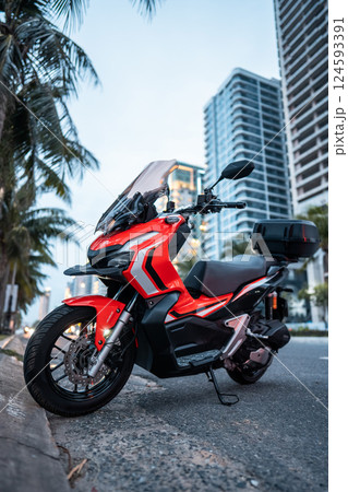 red aggressive motorbike or maxi scooter parked in big modern city red aggressive motorbike or maxi scooter parked in big modern city 124593391