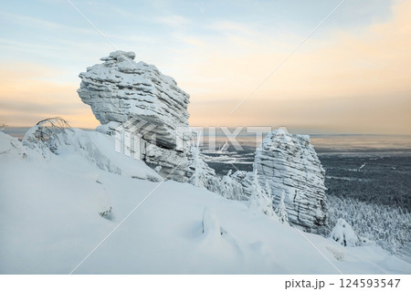 Winter landscape with a bizarre cliff above taiga 124593547