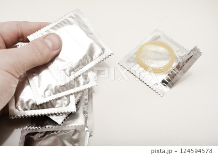An open condom in a package. Male contraceptives. The condom is in your hand. An open condom in a package. Male contraceptives. The condom is in your hand. 124594578