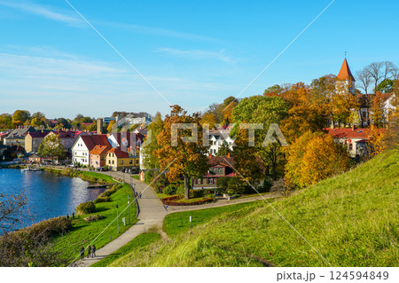 Beautiful view of Talsi Old Town with a white church tower and trees in autumn colors with blue sky 124594849
