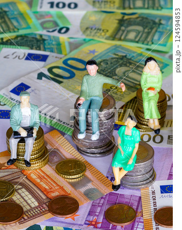 Puppet figures sitting on stacks of coins of different heights, background of money banknotes 124594853