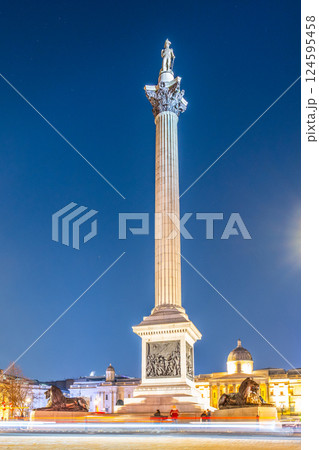 Nelson's Column stands tall in Trafalgar Square at night, surrounded by historical architecture and glowing under the city lights. The monument honors Vice-Admiral Horatio Nelson's victory. Nelson's Column stands tall in Trafalgar Square at night, surrounded by historical architecture and glowing under the city lights. The monument honors Vice-Admiral Horatio Nelson's victory. 124595458
