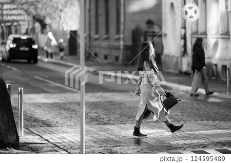 Stroll through the quiet streets of an urban landscape during the late afternoon with pedestrians navigating the cobbled paths in a timeless black and white setting 124595489
