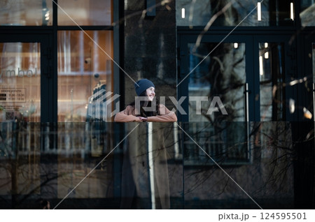 Young woman enjoys a tranquil moment outdoors, leaning against a sleek glass railing in a cozy urban setting during a cool afternoon in late autumn Young woman enjoys a tranquil moment outdoors, leaning against a sleek glass railing in a cozy urban setting during a cool afternoon in late autumn 124595501