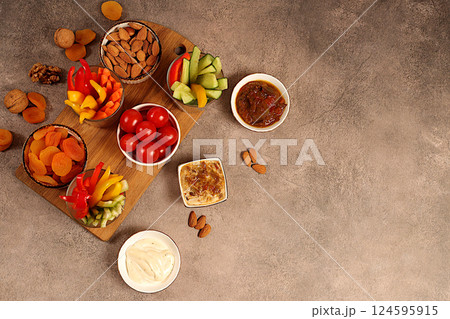 Healthy food kitchen background with hummus bowl and raw vegetable sticks, nuts and dried apricots. Hummus platter with appetizers, Middle Eastern plate, traditional vegan snacks, oriental cuisine Healthy food kitchen background with hummus bowl and raw vegetable sticks, nuts and dried apricots. Hummus platter with appetizers, Middle Eastern plate, traditional vegan snacks, oriental cuisine 124595915