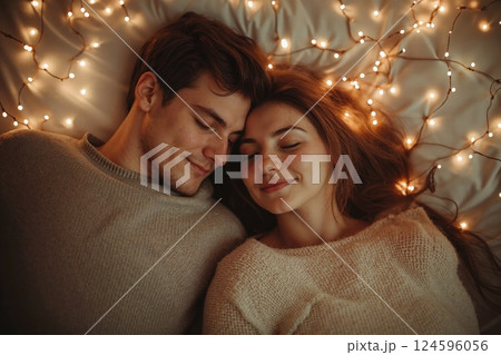 Cozy romantic evening: couple relaxing amidst twinkling fairy lights for relaxation and warmth 124596056