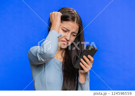 Woman use smartphone typing browsing loses becoming surprised sudden lottery result bad fortune Woman use smartphone typing browsing loses becoming surprised sudden lottery result bad fortune 124596559