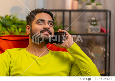 Happy Indian man involved in pleasant conversation phone call good news enjoying talking gossip Happy Indian man involved in pleasant conversation phone call good news enjoying talking gossip 124596581