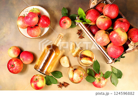 Apple cider, juice, vinegar or fermented drink and fresh apples on a sunny table. Autumn banner. Diet and weight loss concept. Healthy eating, body detoxification, apples help cleanse the body 124596882